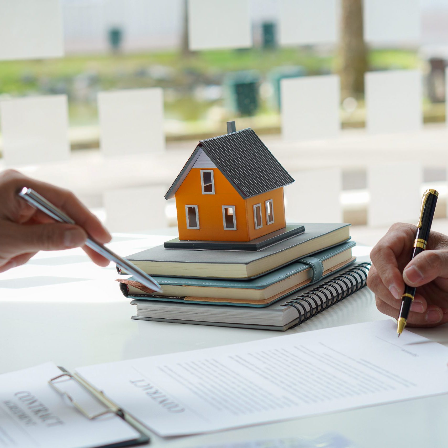 The real estate agent or bank officer explains the interest on the loan to the customer with a home loan agreement to his client after signing the contract. real estate concept