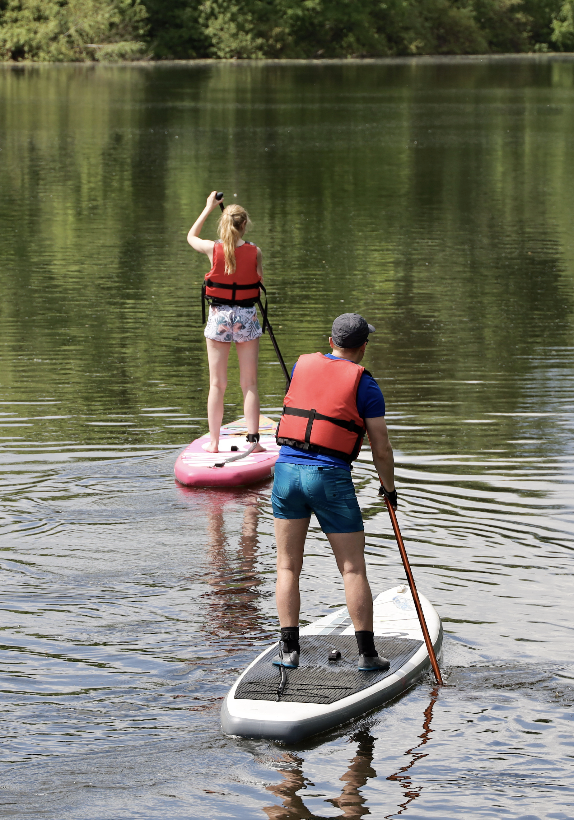 2 People Paddleboarding on River